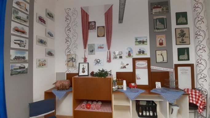 Historischer Raum mit Dekorationen, Möbeln und Bildern an den Wänden.